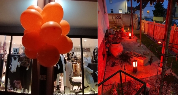 Orangefarbene Luftballons vor den Geschäften und beleuchtetes Privathaus